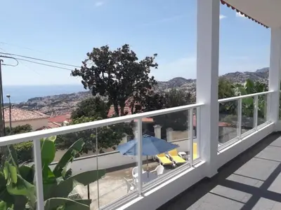 a view from the balcony of a house with an umbrella at Madeira Panoramic Villa- Promoção 2 ou 3 semana in Funchal