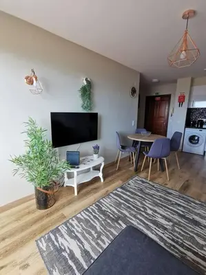 a living room with a tv and a table with chairs at Alegria A in Funchal