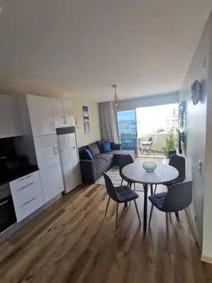 a kitchen and a living room with a table and chairs at Alegria A in Funchal
