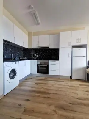 a kitchen with white cabinets and a washer and dryer at Alegria A in Funchal