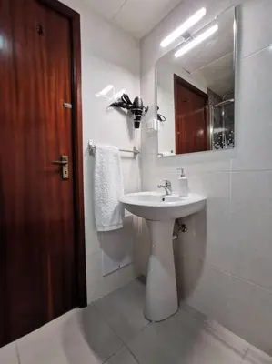 a white bathroom with a sink and a mirror at Alegria A in Funchal