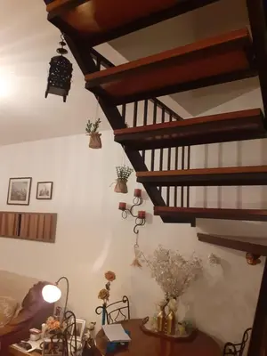 a living room with wooden stairs and a table at Cantinho da Maria in Funchal