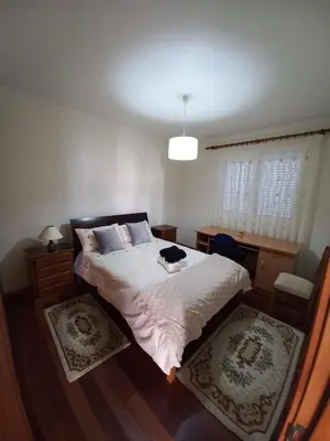 a bedroom with a large bed with white sheets at Casa Abreu Gouveia in Ponta do Pargo in Calheta