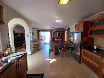 a kitchen and living room with a table and chairs at Casa Abreu Gouveia in Ponta do Pargo in Calheta