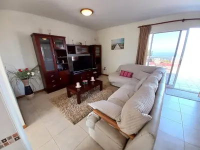 a living room with a couch and a tv at Casa Abreu Gouveia in Ponta do Pargo in Calheta