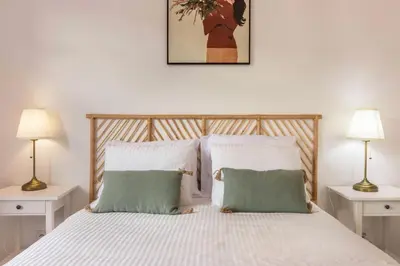a bedroom with a white bed with two lamps at Casa da Olides - T3 in Santana