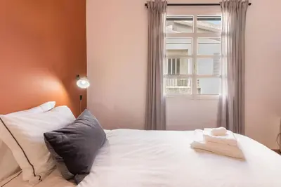a bedroom with a white bed with a window at Casa da Olides - T3 in Santana