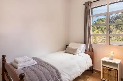 a small bedroom with a bed and a window at Casa da Olides - T3 in Santana