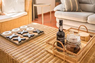 a bottle of wine on a table in a living room at Casa da Olides - T3 in Santana