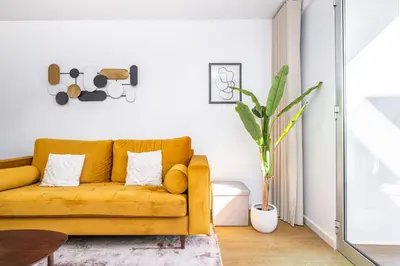 a living room with a yellow couch and a table at Casa Branca 360 - Penthouse - By Wehost in Funchal
