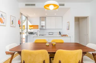 a kitchen and dining room with a wooden table and chairs at Casa Branca 360 - Penthouse - By Wehost in Funchal