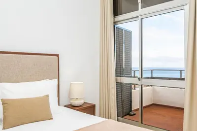 a bedroom with a bed and a large window at Casa Branca 360 - Penthouse - By Wehost in Funchal