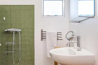 a bathroom with a sink and a shower with green tiles at Casa Branca 360 - Penthouse - By Wehost in Funchal