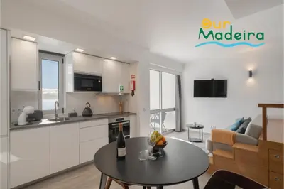 a kitchen and a living room with a table at Premium quiet apt Funchal seafront Oceanbreeze in Funchal