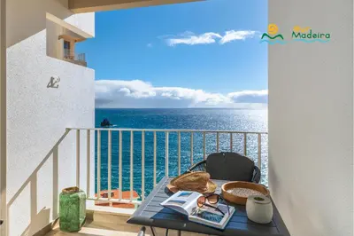 a balcony with a table and a view of the ocean at Premium quiet apt Funchal seafront Oceanbreeze in Funchal