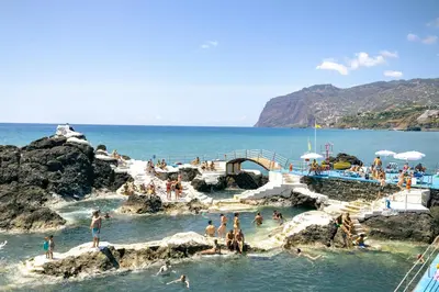 a group of people in the water at a beach at Premium quiet apt Funchal seafront Oceanbreeze in Funchal