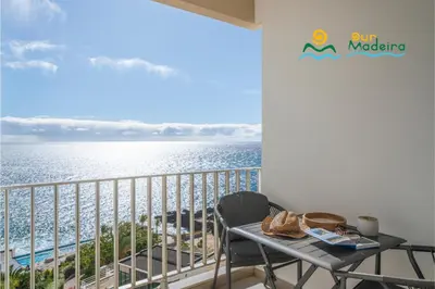 a balcony with a table and a view of the ocean at Premium quiet apt Funchal seafront Oceanbreeze in Funchal