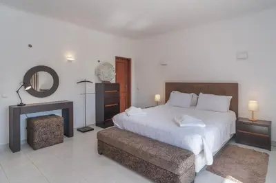 a bedroom with a large white bed and a fireplace at Casa Limonte in Luz