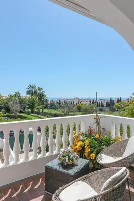 a balcony with wicker chairs and a white railing at Casa Limonte in Luz