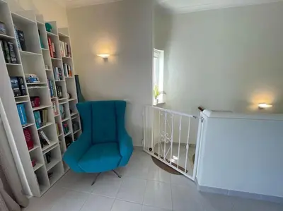 a room with a blue chair and book shelves at Casa Limonte in Luz