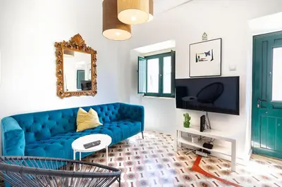 a living room with a blue couch and a mirror at Casa Levante in Sagres