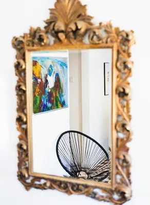 a mirror with a basket in front of a painting at Casa Levante in Sagres
