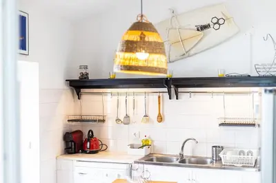 a kitchen with a sink and a shelf with utensils at Casa Levante in Sagres