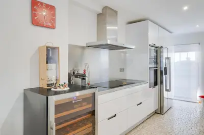 a kitchen with white cabinets and a stainless steel refrigerator at Casa Clarisse by Holiday Rental Madeira in Funchal