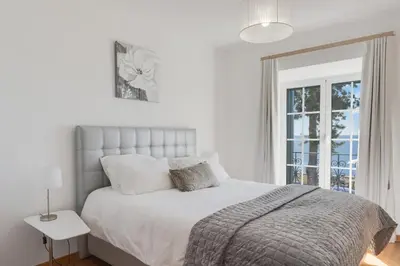 a white bedroom with a bed and a window at Casa Clarisse by Holiday Rental Madeira in Funchal