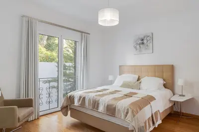 a white bedroom with a bed and a window at Casa Clarisse by Holiday Rental Madeira in Funchal