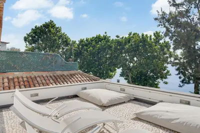 a white chair and pillows on a balcony at Casa Clarisse by Holiday Rental Madeira in Funchal