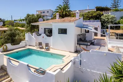 a villa with a swimming pool and a house at CoolHouses Algarve, Luz, 3 Bed villa, 1 bed studio, heated pool & jacuzzi, sea views, Casa Pequena in Luz