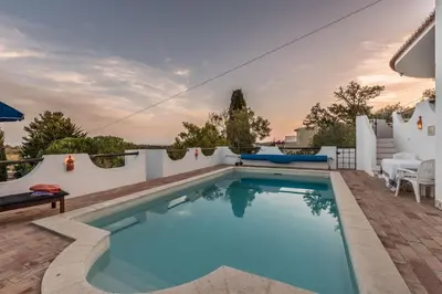 a swimming pool on the back of a house at CoolHouses Algarve, Luz, 3 Bed villa, 1 bed studio, heated pool & jacuzzi, sea views, Casa Pequena in Luz