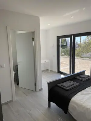a bedroom with a bed and a sliding glass door at CoolHouses Algarve, Luz, 3 Bed villa, 1 bed studio, heated pool & jacuzzi, sea views, Casa Pequena in Luz