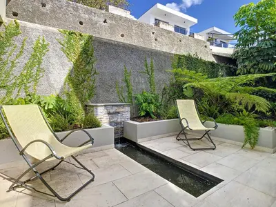 two chairs sitting on a patio next to a wall at Francelho 1 Apartment by LovelyStay in Ribeira Brava