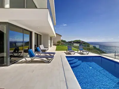 a house with a swimming pool next to the ocean at Francelho 1 Apartment by LovelyStay in Ribeira Brava