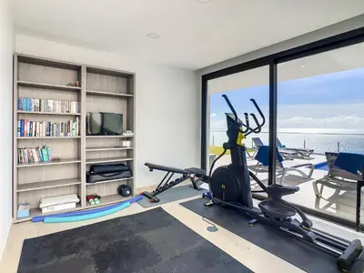 a room with a gym with a view of the ocean at Francelho 2 Aparment by MHM in Ribeira Brava