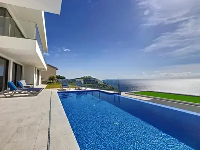 a swimming pool in front of a house with the ocean at Francelho 2 Aparment by MHM in Ribeira Brava