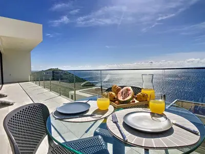 a table with a plate of food and glasses of orange juice at Francelho 2 Aparment by MHM in Ribeira Brava