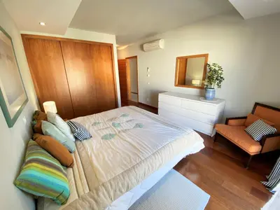 a bedroom with a large bed and a chair at Apartamento Dolce Vita in Luz