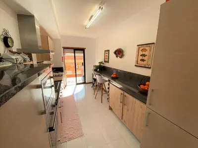 a large kitchen with a counter top and a dining room at Apartamento Dolce Vita in Luz