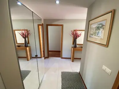 a hallway with a glass door and two vases with flowers at Apartamento Dolce Vita in Luz