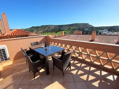 a patio with a table and chairs on a balcony at Apartamento Dolce Vita in Luz