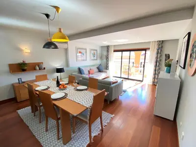 a dining room and living room with a table and chairs at Apartamento Dolce Vita in Luz