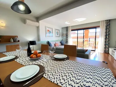 a dining room with a table with plates and wine glasses at Apartamento Dolce Vita in Luz