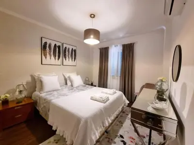 a bedroom with a white bed and a table at Kiara's Cantinho do Mar by Rentallido in Funchal