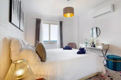 a bedroom with a white bed and a window at Kiara's Cantinho do Mar by Rentallido in Funchal