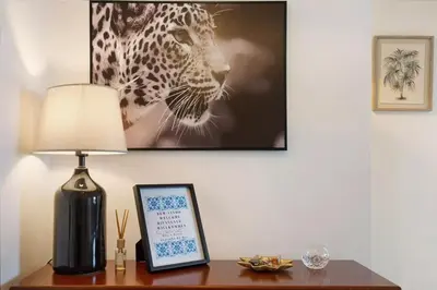 a table with a lamp and a picture of a leopard at Kiara's Cantinho do Mar by Rentallido in Funchal