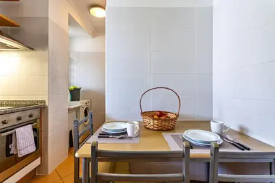 a kitchen with a table with plates and a basket on it at MCR Funchal in Funchal