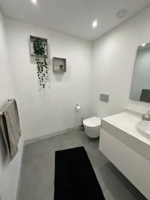a white bathroom with a toilet and a sink at Deluxe Bay View in Câmara de Lobos